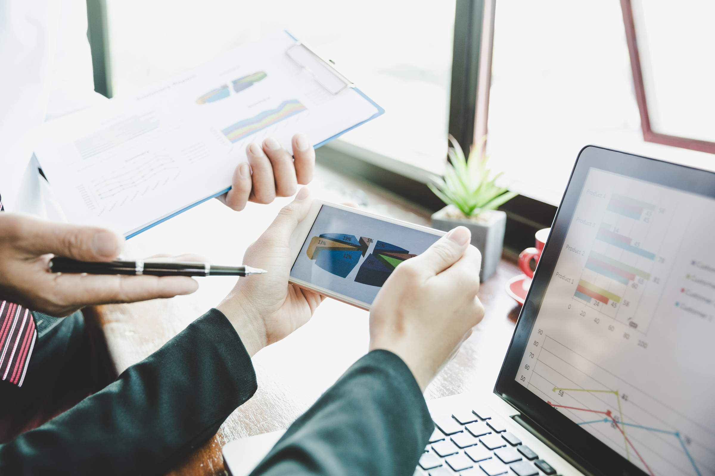 business team analyzing income charts and graphs on smartphone close up