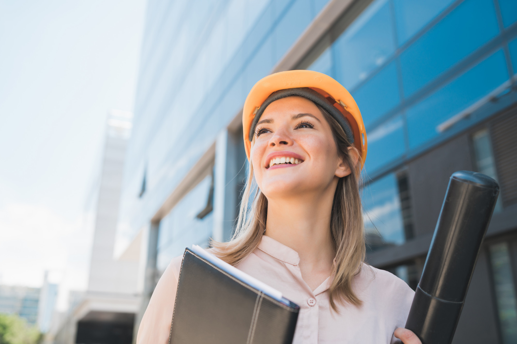 portrait of professional architect woman wearing yellow helmet and standing outdoors engineer and architect concept