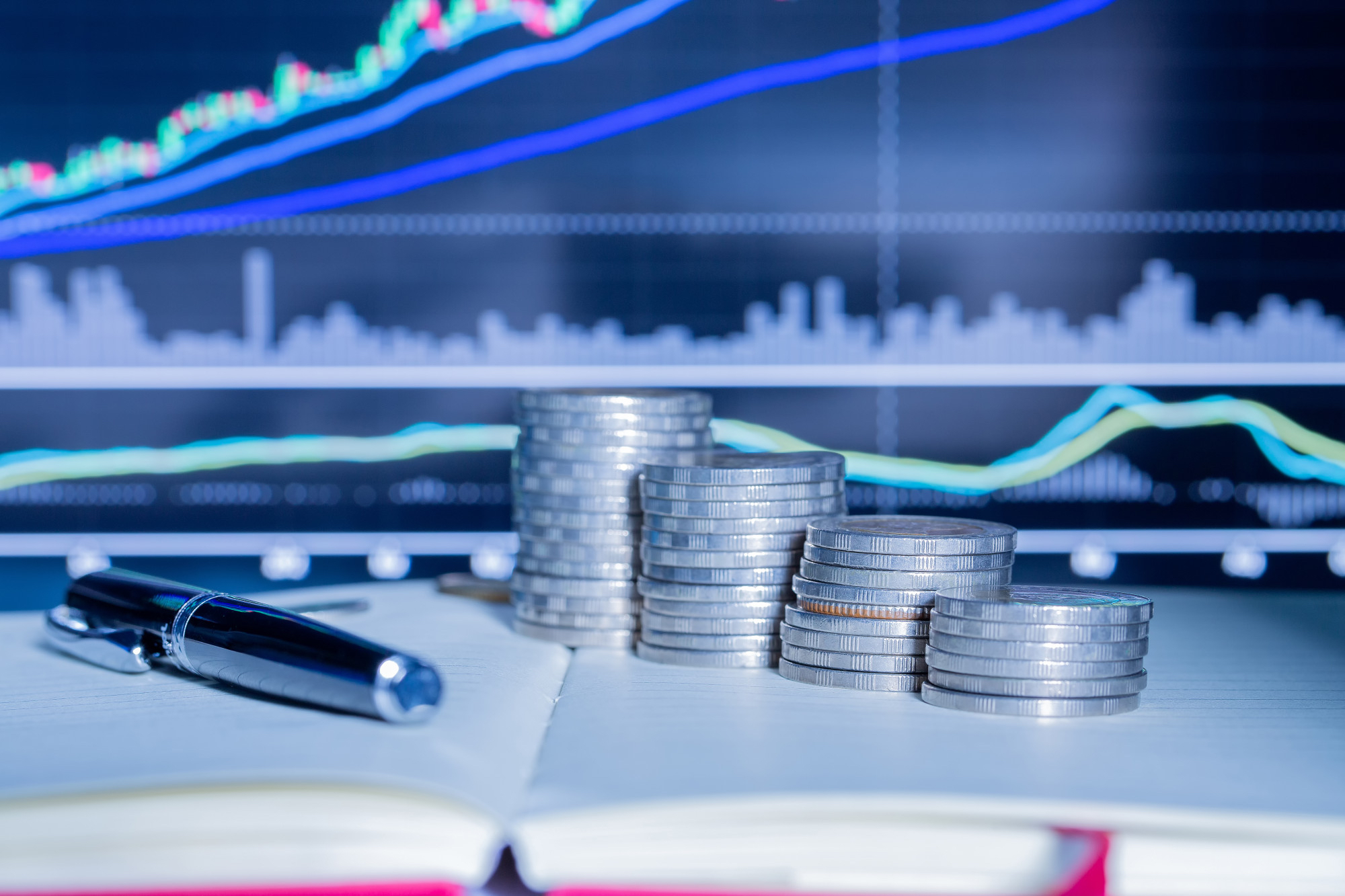 stack of money coin with trading graph
